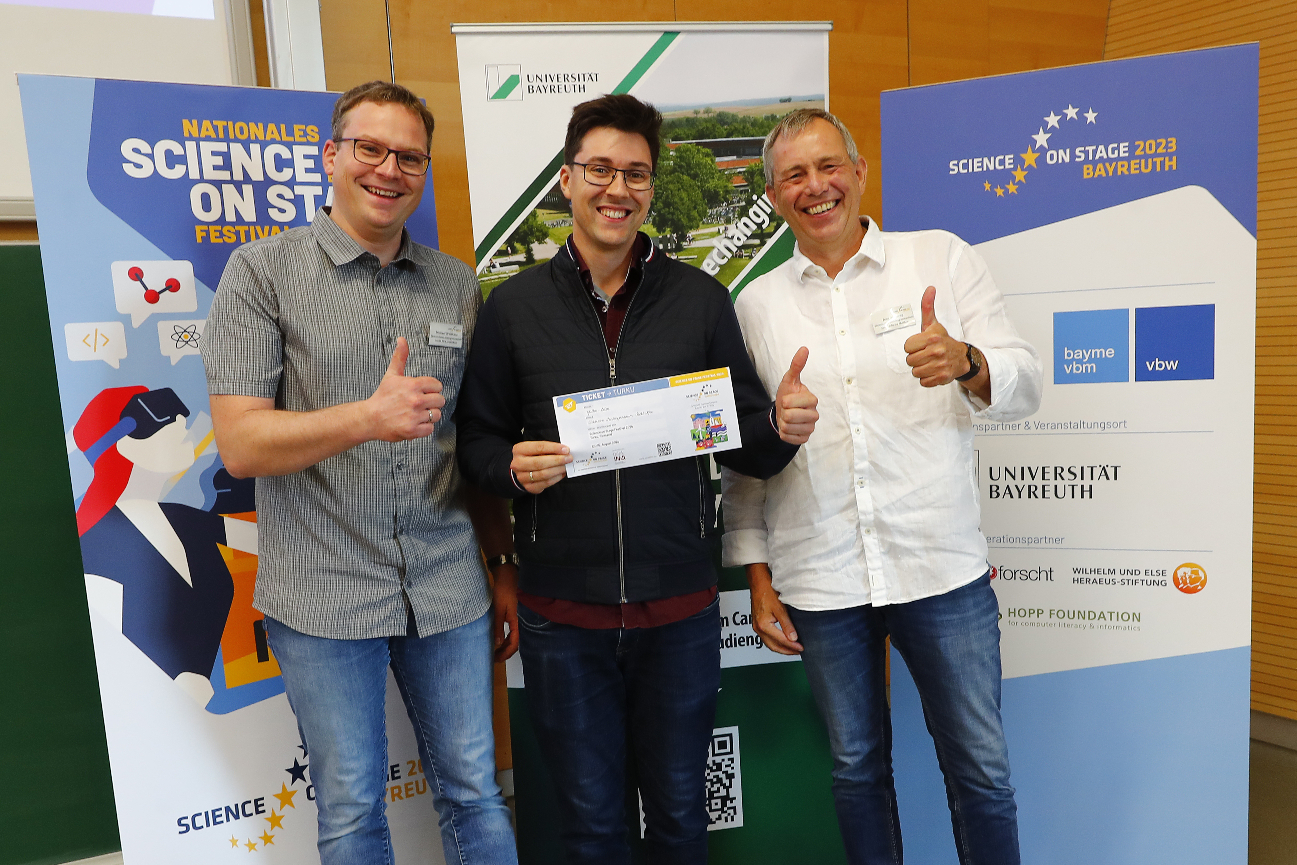 Michael Weidhase, Marius Schumann und Jens Viehweg halten ihr Ticket für das Europäische Science on Stage Festival in den Händen