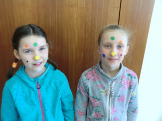Zwei Schülerinnen mit Klebepunkten im Gesicht