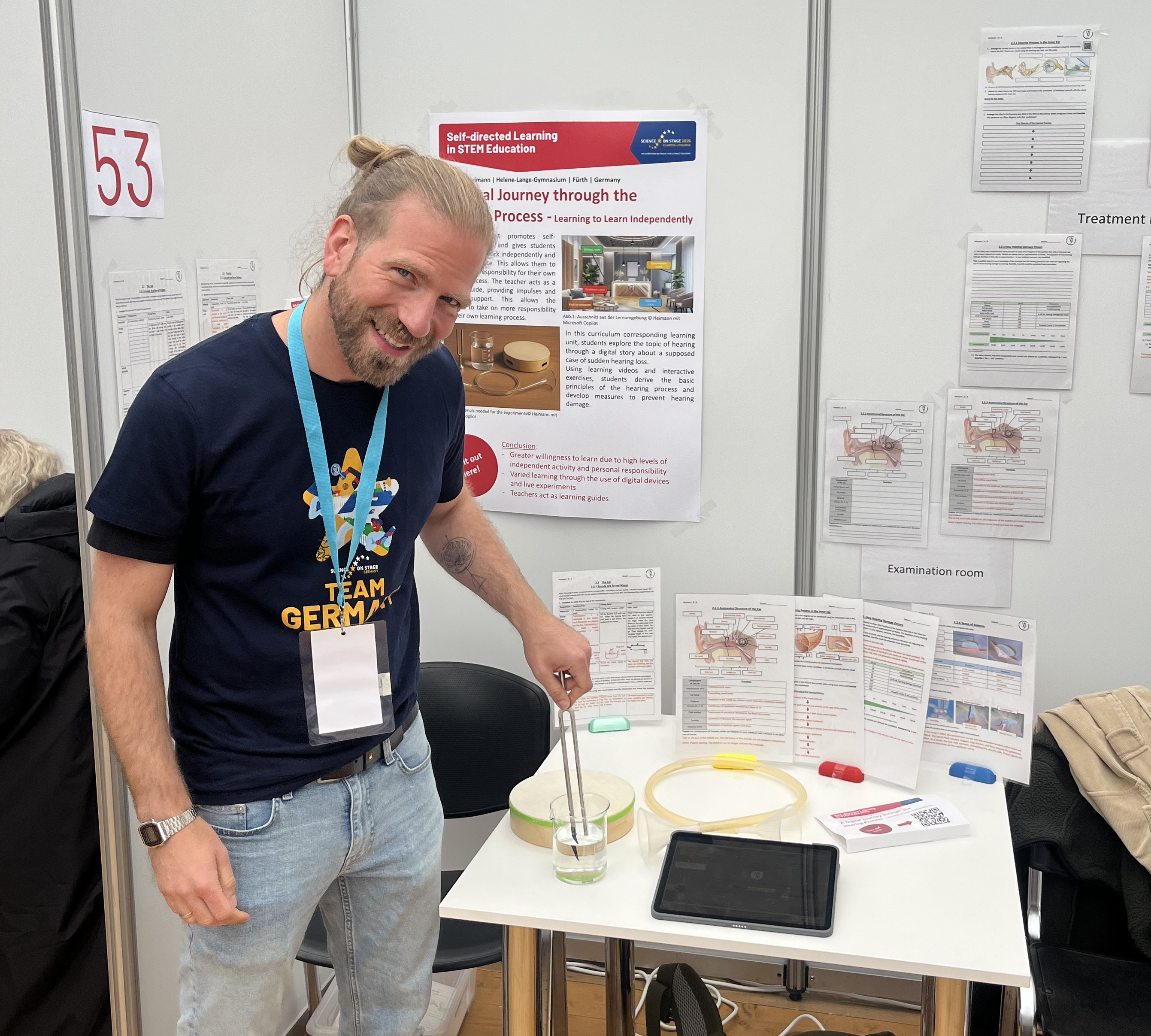 Ein Mann steht an einem Messestand.