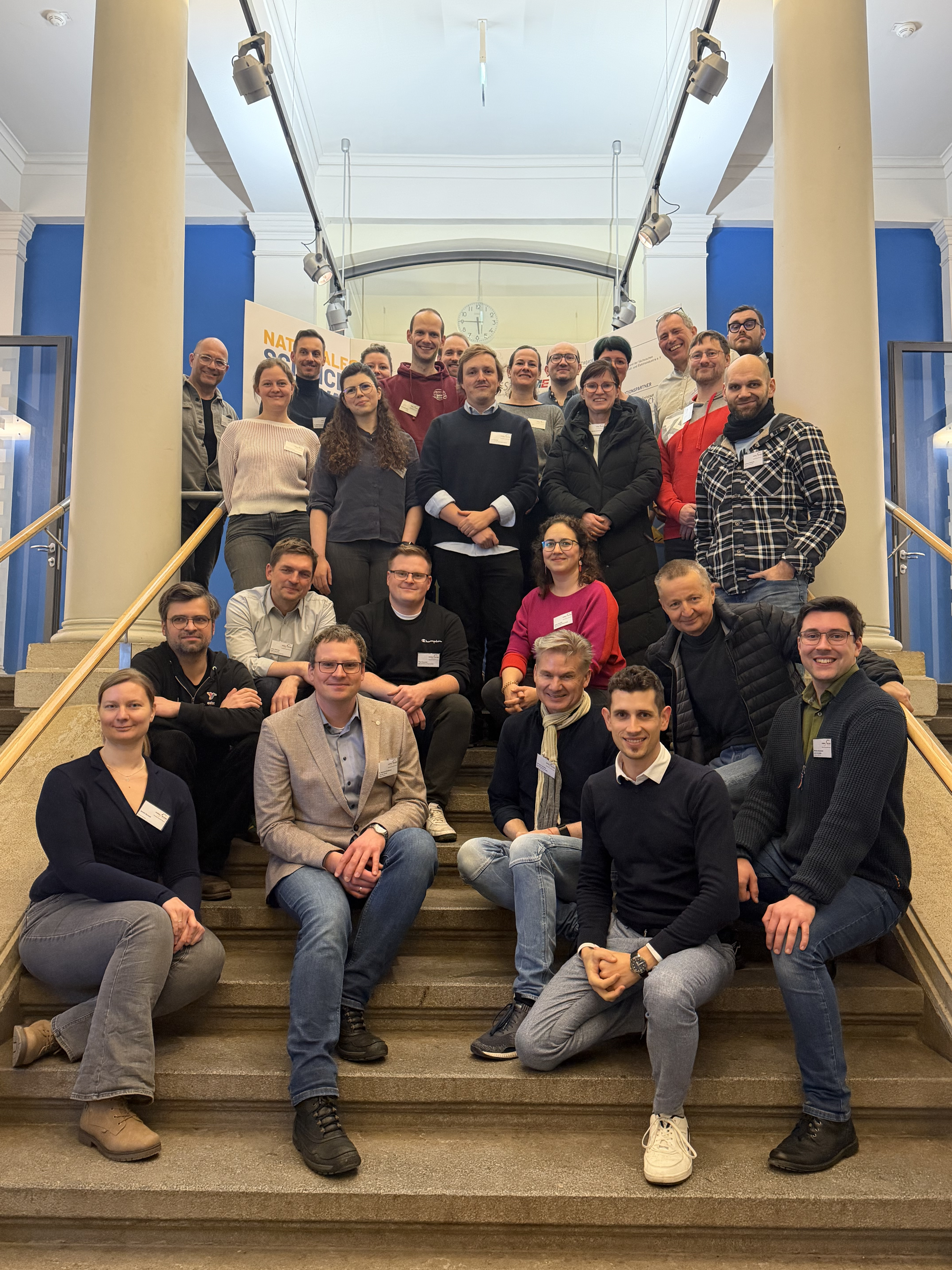 Gruppenfoto mit 26 Personen auf einer Treppe