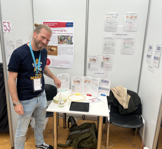Ein Mann steht an einem Messestand.