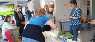 Personen stehen um einen Tisch während einer Fortbildung