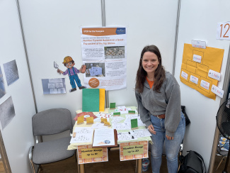 Eine Frau steht an einem Messestand.