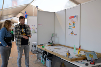 Zwei Personen stehen an einem Messestand.