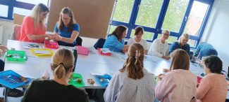 Personen sitzen an einem Tisch während einer Fortbildung