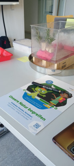 Broschüre des Unterrichtsmaterials "Unsere Natur begreifen" liegt auf einem Tisch