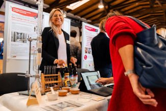 Eine Besucherin und eine Ausstellerin an einem Stand der Bildungsmesse