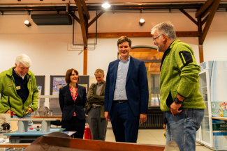 Mehrere Personen in lockerem Gespräch am Stand einer Bildungsmesse