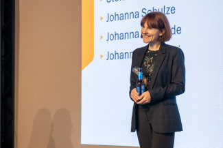 Eine Frau mit einer Flasche in der Hand auf einer Bühne