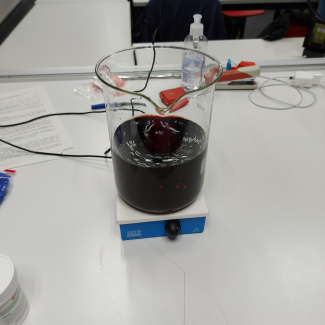 ein Becherglas mit einer dunklen Flüssigkeit