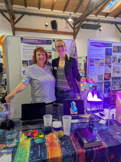 Zwei Ausstellerinnen an einem bunten Messestand